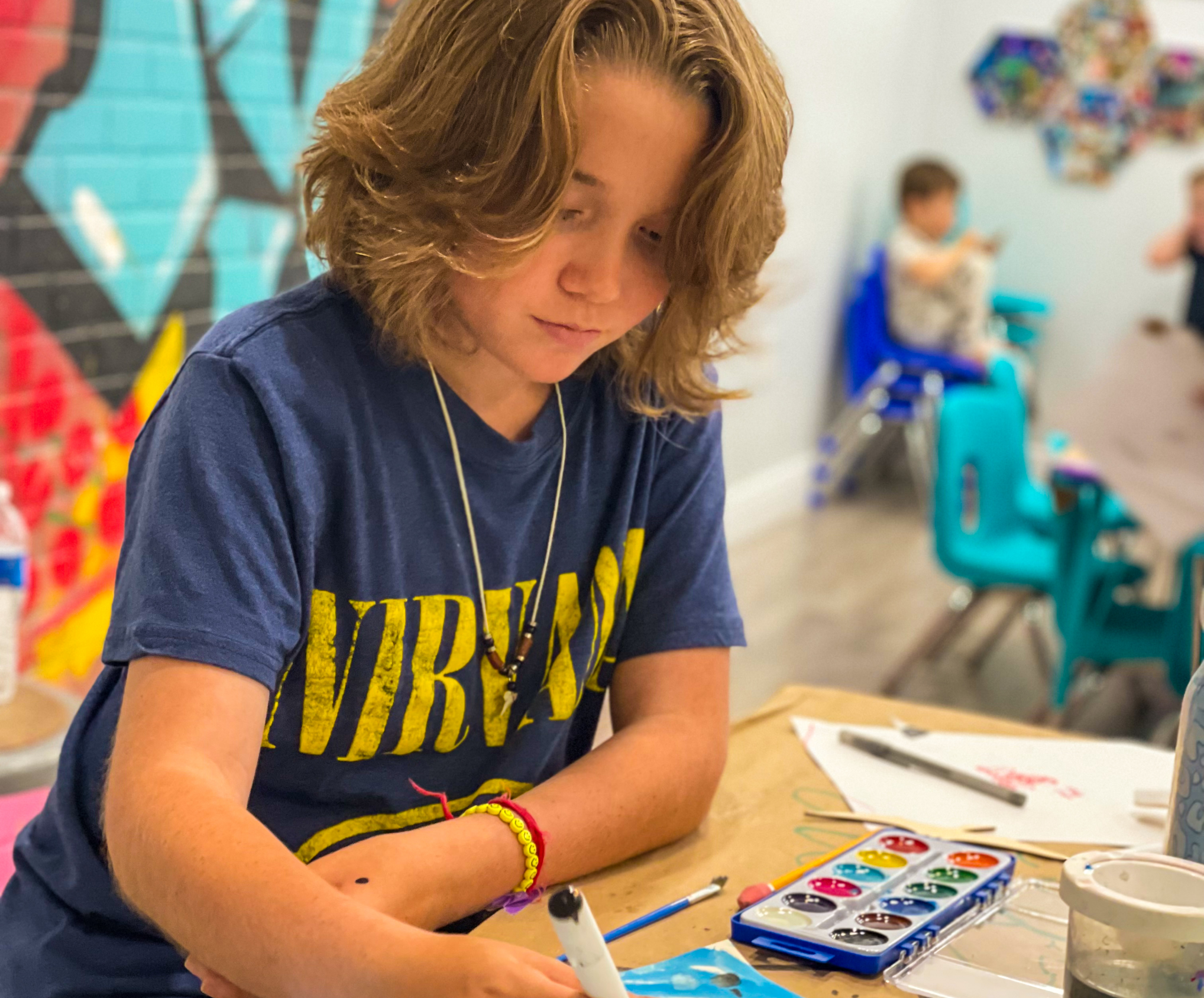 Young artists enjoying mixed-media projects at Artnest Studio